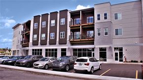 East Lansing apartment for rent - a parking lot with cars in front of an apartment building