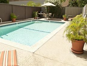 Tarzana apartment for rent - the pool is surrounded by potted plants and a fence