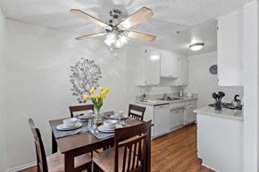 Northridge apartment for rent - The dining room and the kitchen with ample natural light, plank flooring, and white cabinetry. The kitchen also includes a dishwasher at the Ridgeview Apartment in Northridge