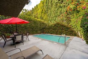 Northridge apartment for rent - The pool at the Ridgeview Apartments in Northridge surrounded by beautifully manicured trees with patio seating and loungers to relax on a warm sunny day