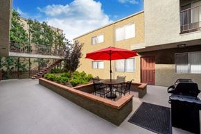 Northridge apartment for rent - The courtyard at the Ridgeview apartment in Northridge with BBQ machine, patio seating, and an elevated planter with beautifully manicured plants.