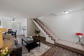 North Hollywood apartment for rent - The living room in a townhome apartment at the Arbor Apartments in Studio City, CA with plank flooring and carpeted staircase to access bedroom and bathroom upstairs.