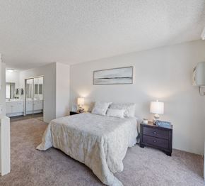 Van Nuys apartment for rent - A bedroom with a large bed and a nightstand with two lamps.