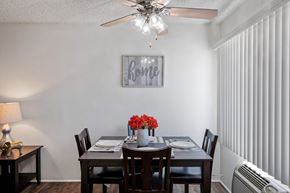 Van Nuys apartment for rent - A dining room with a table set for four and a fan on the ceiling.