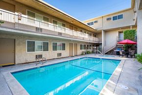 Van Nuys apartment for rent - A rectangular sparkling blue swimming pool at Esplanade apartments surrounded by outdoor walkways.