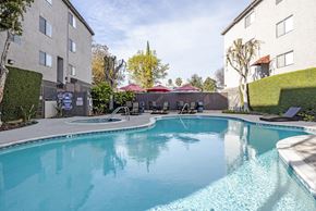 Lake Balboa apartment for rent - a resort style pool with chairs and umbrellas next to a building