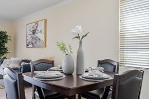 Northridge apartment for rent - a dining room table with three vases with flowers on it