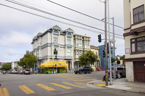 San Francisco apartment for rent - A street view with a building on the left and a car on the road.