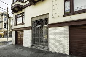 San Francisco apartment for rent - A white building with a brown door and a window.