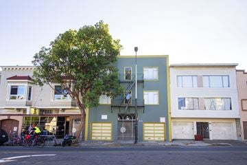 San Francisco apartment for rent - A tree in front of a building with a yellow gate.