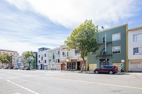 San Francisco apartment for rent - A street view with a red car parked on the side of the road.