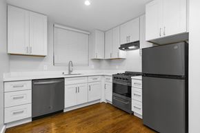 San Francisco apartment for rent - A modern kitchen with white cabinets and a black refrigerator.