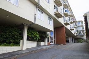 San Francisco apartment for rent - A long white building with balconies and a brown door.