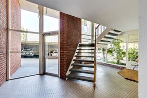 San Francisco apartment for rent - A view of a hallway with a brick wall and a staircase.