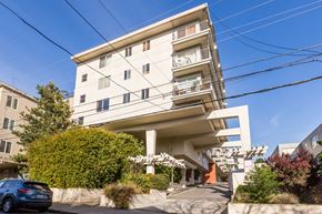 San Francisco apartment for rent - A modern white apartment building with a car parked in front.