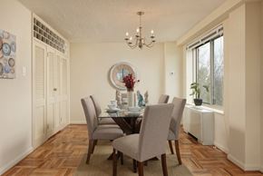 Washington apartment for rent - Elegant dining room with glass table and chandelier at 4000 Massachusetts Avenue Apartments, Washington, DC 20016
