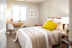 Omaha apartment for rent - A bedroom with a bed, desk, chair, and window.