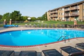 Omaha apartment for rent - A large swimming pool with lounge chairs around it.