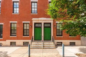 Philadelphia townhouse for rent - the front of a red brick building with green doors