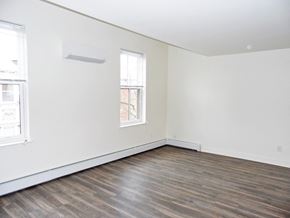 Philadelphia townhouse for rent - an empty room with white walls and wood floors and a window