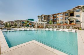 Fort Worth apartment for rent - Resort-style swimming pool featuring crystal-clear water, in-water lounge seating, shaded gathering areas, and expansive sundeck space.