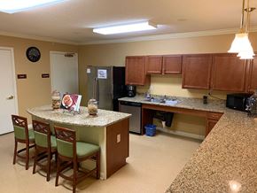 Baltimore apartment for rent - Community room kitchen with a granite countertop and wooden cabinets.