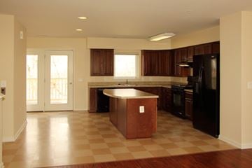 Aberdeen apartment for rent - A kitchen with a black refrigerator and brown island.