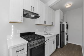 San Francisco apartment for rent - A kitchen with white cabinets and a black stove top oven.