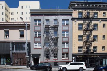 San Francisco apartment for rent - A black car is parked in front of a building with a fire escape.