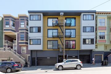 San Francisco apartment for rent - A row of modern apartment buildings with cars parked in front.