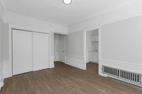 San Francisco apartment for rent - A room with white walls and wooden floors with a radiator on the side.