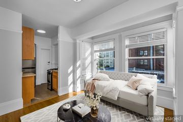 San Francisco apartment for rent - A living room with a white couch and a coffee table with a vase of flowers on it.