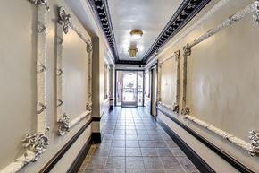 San Francisco apartment for rent - A long hallway with a black tile floor and white walls with gold trim.
