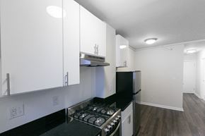 San Francisco apartment for rent - A kitchen with white cabinets and a black countertop.