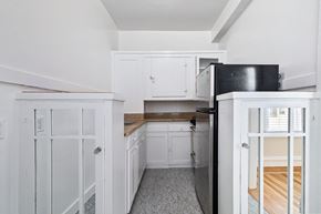 San Francisco apartment for rent - A kitchen with white cabinets and a black fridge.