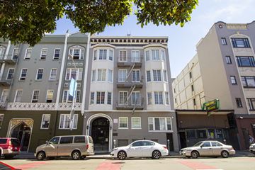 San Francisco apartment for rent - A street view of a building with cars parked in front.
