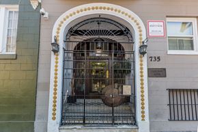 San Francisco apartment for rent - A gate with a sign that says "Rentshon" is in front of a building.