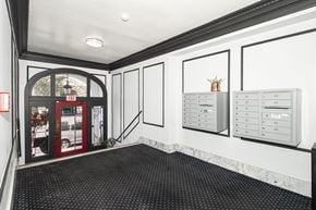 San Francisco apartment for rent - A hallway with a red door and a white wall with a calendar on it.