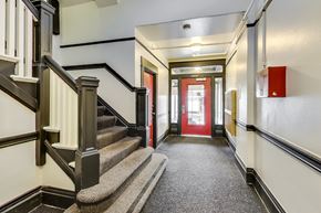 San Francisco apartment for rent - A hallway with a staircase on the left and a red door on the right.