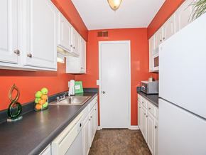 Clarksville apartment for rent - a kitchen with white cabinets and a sink and a refrigerator