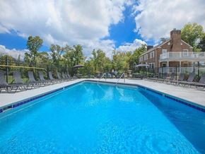 Knoxville apartment for rent - a large pool with chairs around it in front of a house