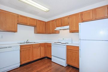 Lebanon apartment for rent - a kitchen with white appliances and wooden cabinets
