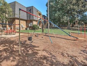 Jackson apartment for rent - a swing set in a playground in front of a building