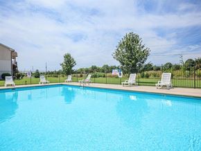 Murfreesboro apartment for rent - a large swimming pool with white chairs around it