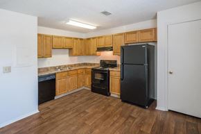 Antioch apartment for rent - a kitchen with wooden cabinets and a black refrigerator