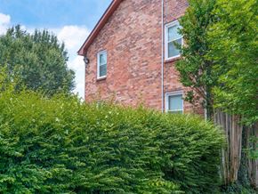 Nashville apartment for rent - the side of a brick house with trees and bushes