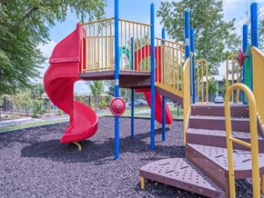 Murfreesboro apartment for rent - a playground with a red slide and a bench in a park