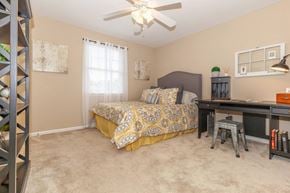 Murfreesboro apartment for rent - a bedroom with a bed and a desk and a ceiling fan