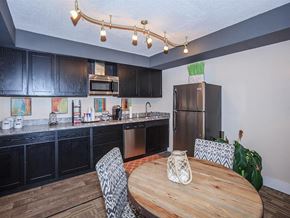 Knoxville apartment for rent - a kitchen with black cabinets and a wooden table