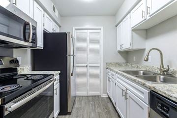 Columbia apartment for rent - a kitchen with white cabinets and black appliances and a sink